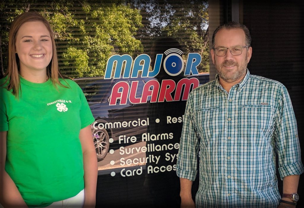 Major Alarm presenting a scholarship to a Forestville 4-H club member